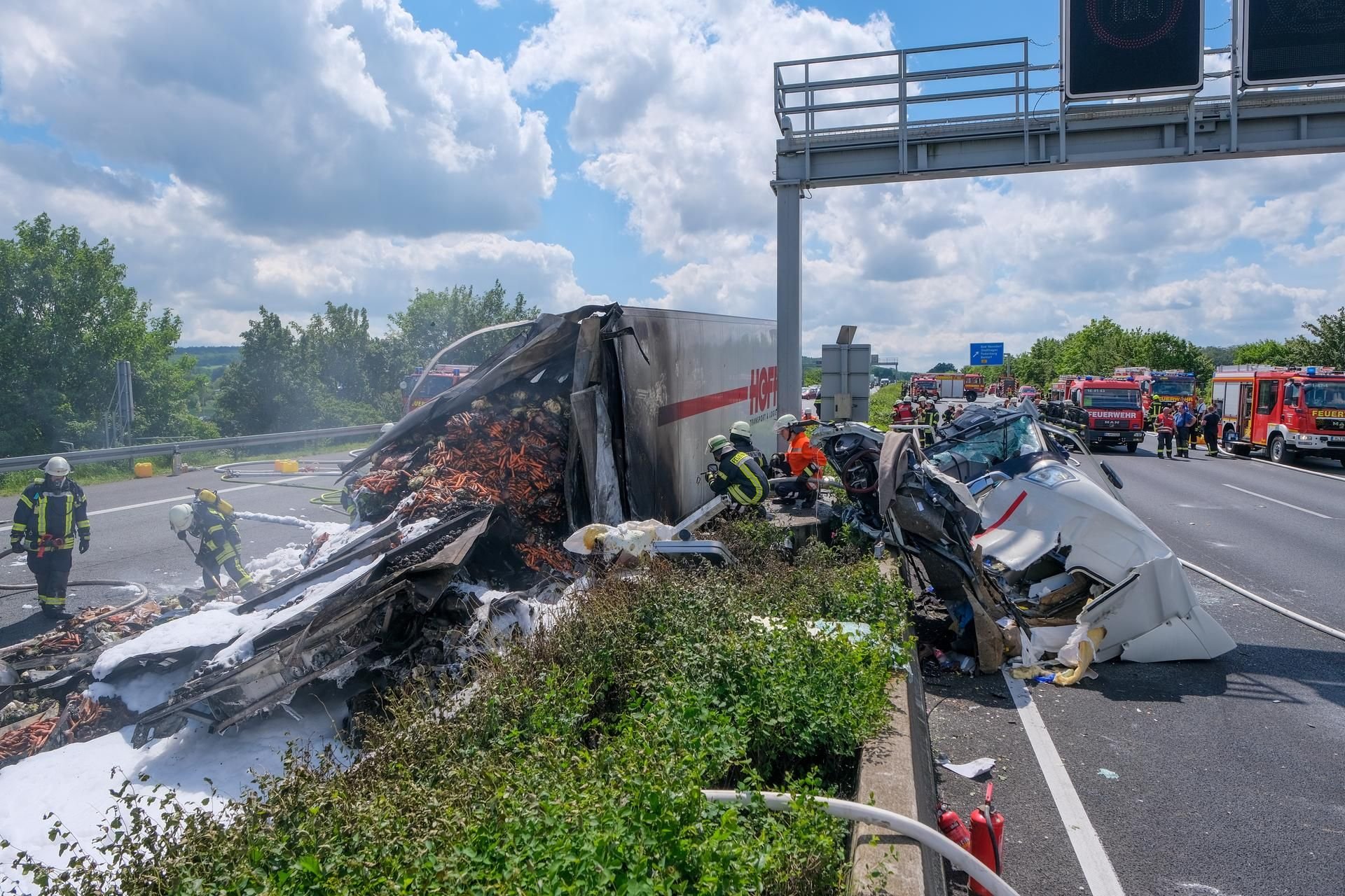 Bad Nenndorf: Feuerwehrleute löschen einen noch qualmenden LKW, der auf der Autobahn 2 nach einem Unfall in Brand geraten war.