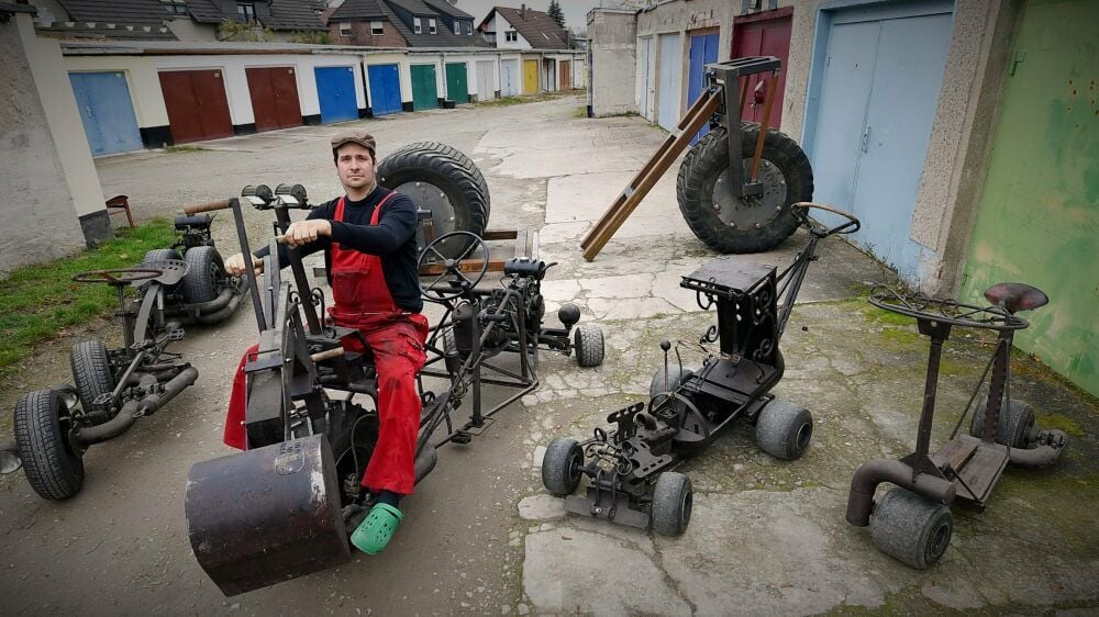 Sebastian Beutler sitzt auf einer Kombination aus Kompressor und Bagger. Im Hintergrund sind die Räder des Guinness-Rades zu sehen.
