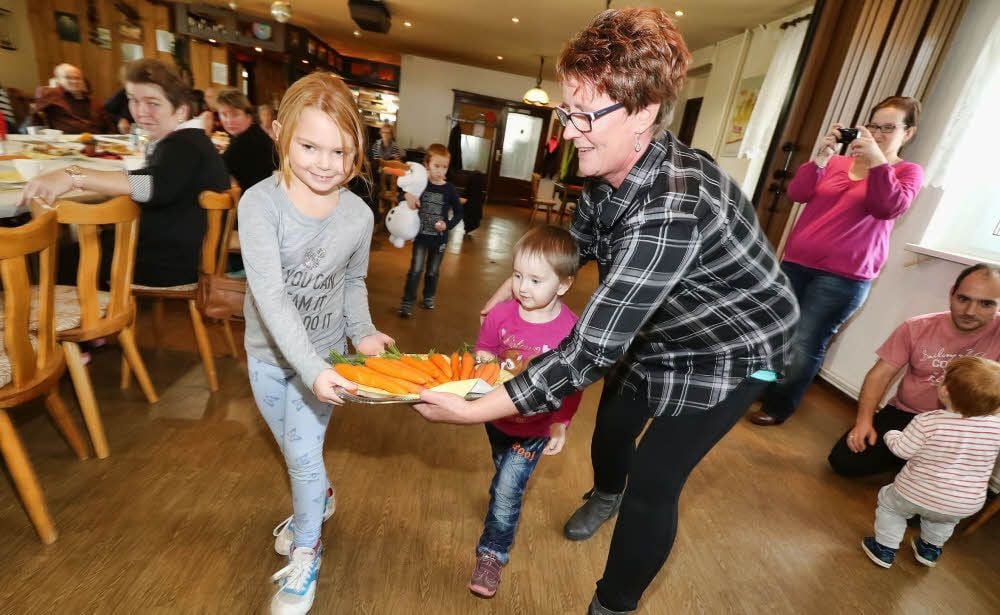 Kim, Lea und Anett Hölzel (v.l.) kredenzen den Gästen selbst geerntete Karotten.