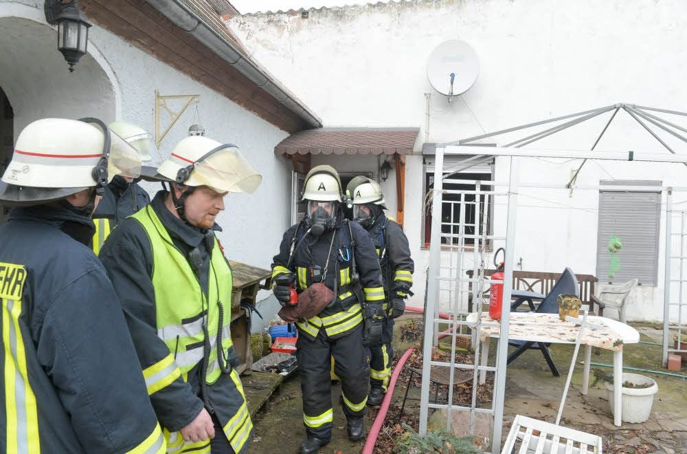 Atemschutzgeräteträger beim Verlassen des rauchgeschwängerten Hauses in Kleinzerbst.