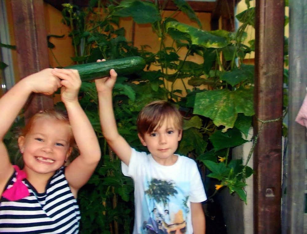 Jason und Kimberly mit einer Gurke aus eigenem Anbau.