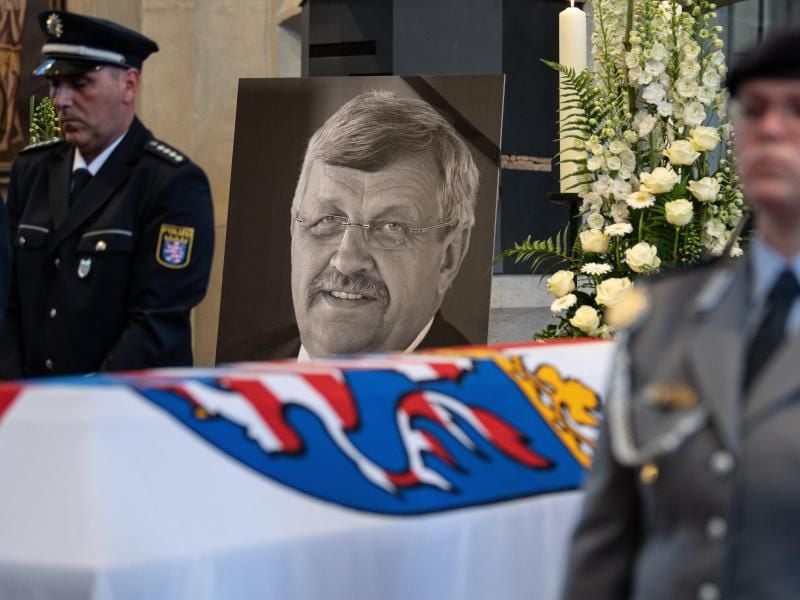 Das Konterfei von Walter Lübcke (CDU) ist hinter einem Bundeswehrsoldaten am Sarg zu sehen. Foto: Swen Pförtner/dpa/Archivbild