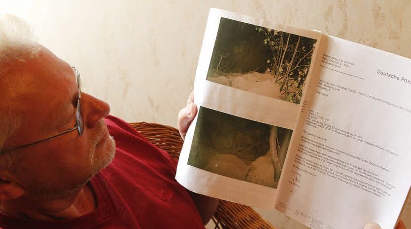 Klockow sieht sich Fotos von den entdeckten Grabungen an.