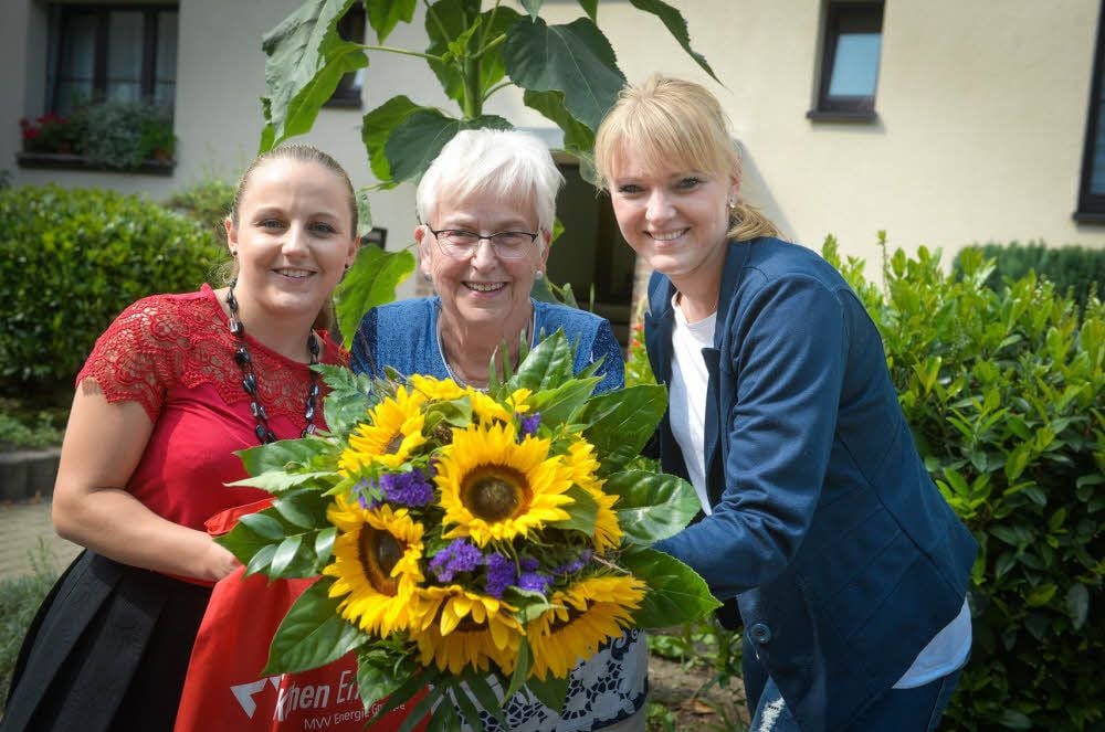 Anne Beck (links) und Franziska Wagner haben Rosemarie Giese einen Strauß mit Sonnenblumen überreicht.