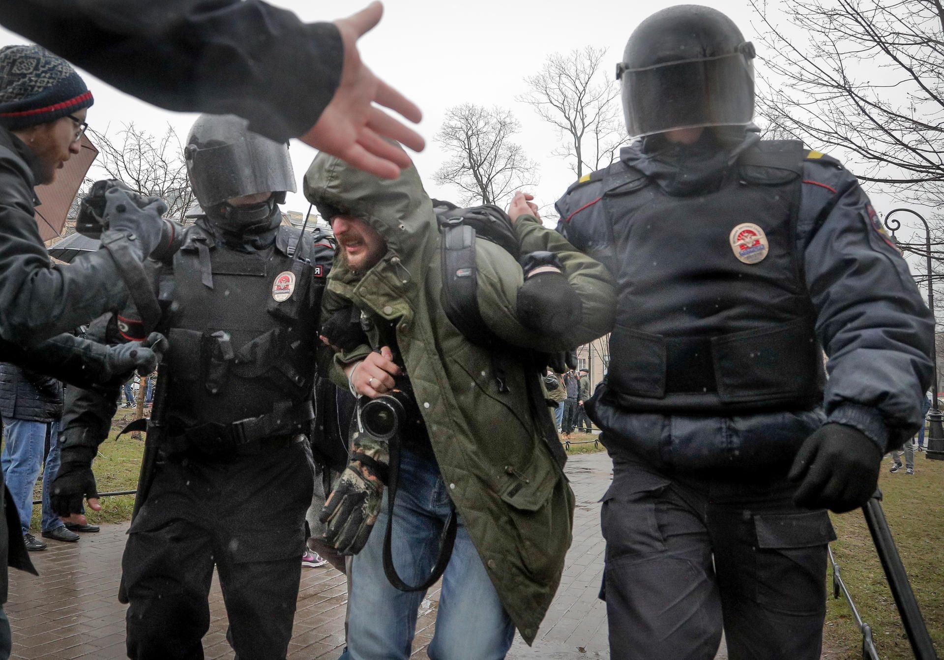 Polizisten nehmen einen russischen Journalisten bei den Protesten in St. Petersburg fest.