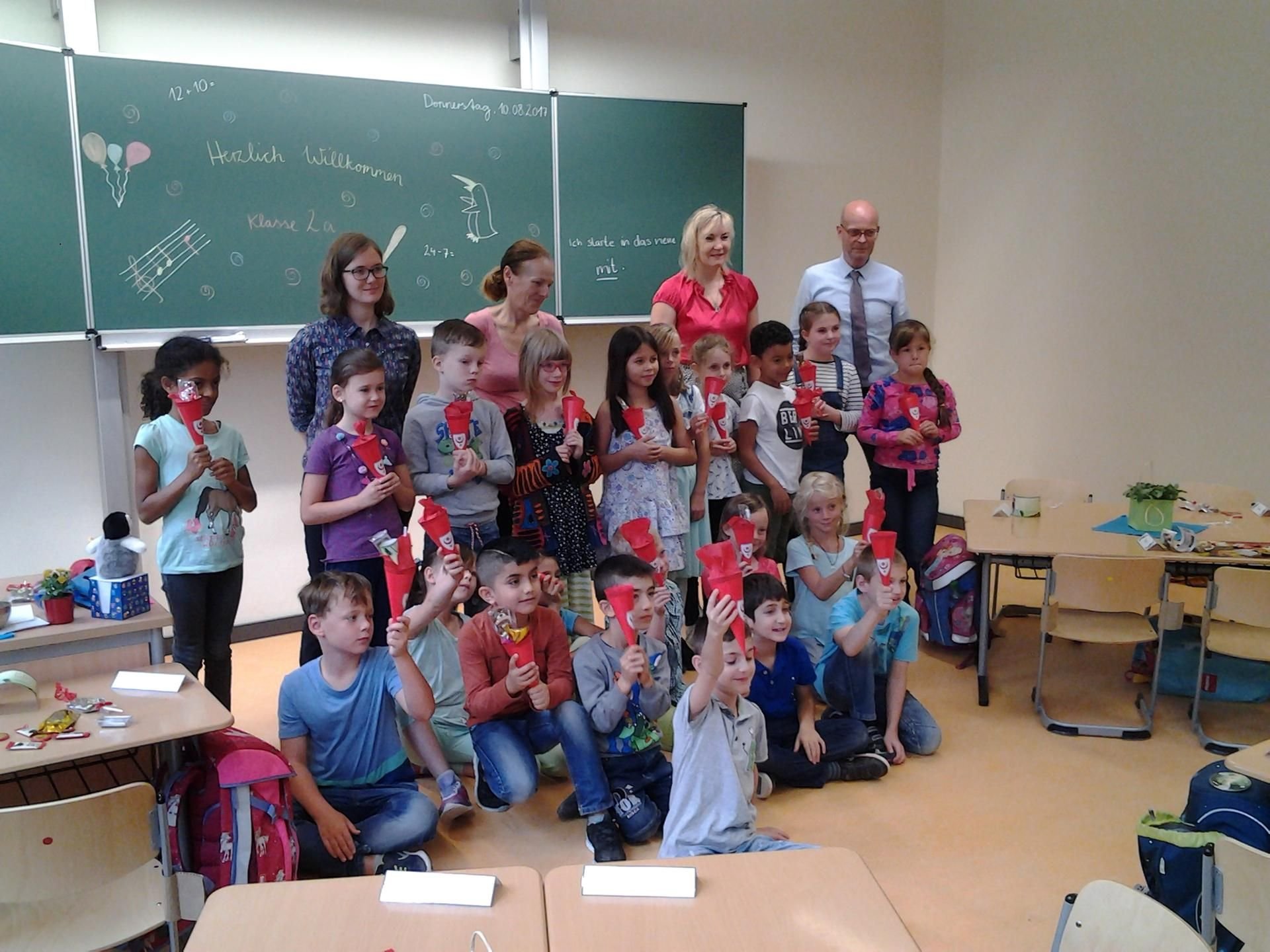 Klassenlehrerin Lene Trinkaus, Beigeordnete Katharina Brederlow, Schulleiterin Jana Eltz und OB Bernd Wiegand begrüßen die ersten Schüler der neuen Grundschule Glaucha. (hintere Reihe von links)