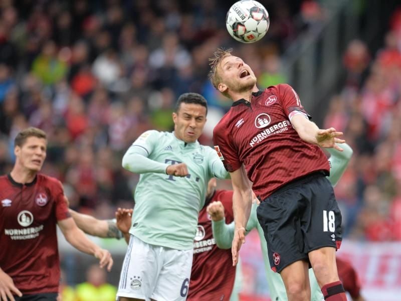 Nürnbergs Hanno Behrens (r) im Kopfballduell gegegn Bayerns Thiago. Foto: Timm Schamberger