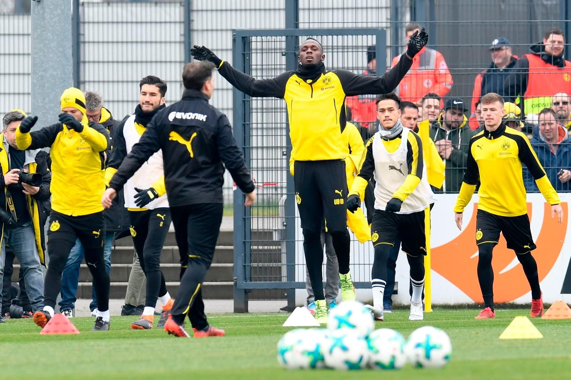 Usain Bolt (m.) beim Aufwärmen mit den BVB-Profis