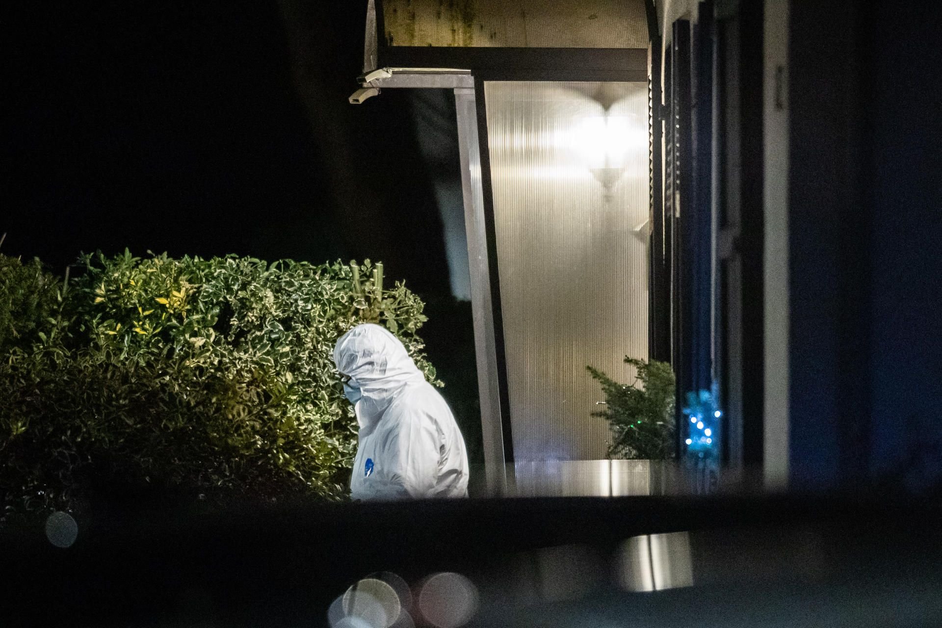 Ein Beamter der Spurensicherung verlässt während eines Polizeieinsatzes ein Haus.