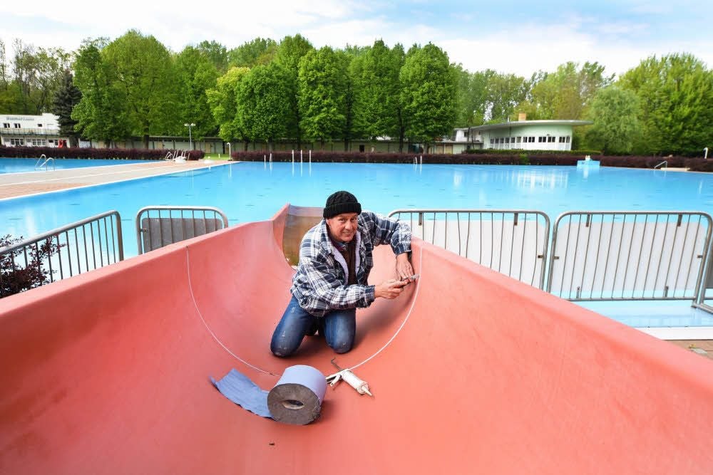 Silvio Dimmer, Hausmeister im Leunaer Waldbad, dichtet die Verbindungsfugen der Rutsche neu ab.