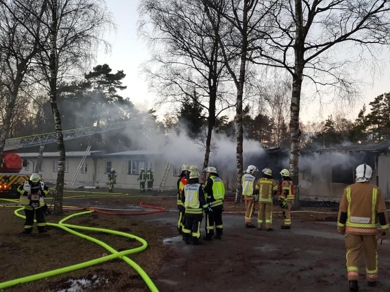 Feuerwehrkräfte löschen den brand in einer Flüchtlingsunterkunft in Hövelhof bei Paderborn. Foto: Ralf Hilker/Kreis Paderborn