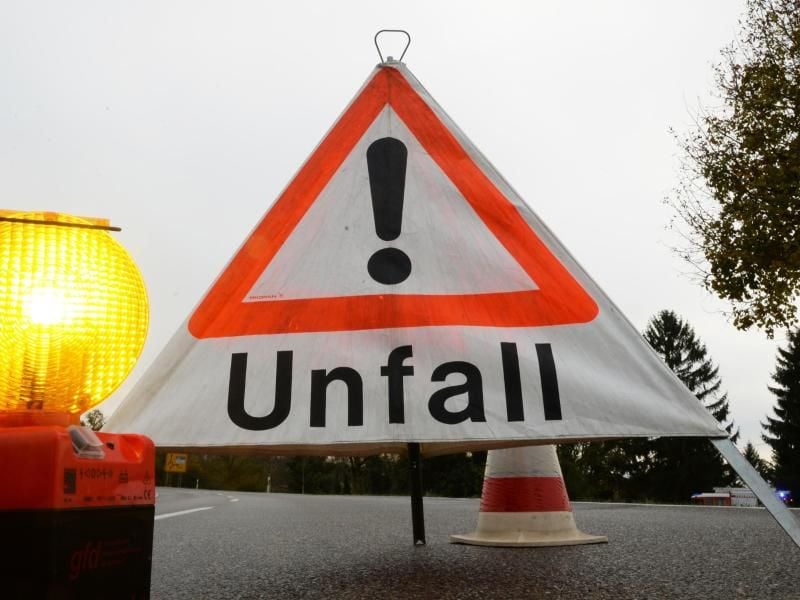 Ein Warndreieck mit der Aufschrift „Unfall” steht auf einer Straße. Foto: Patrick Seeger/Archiv