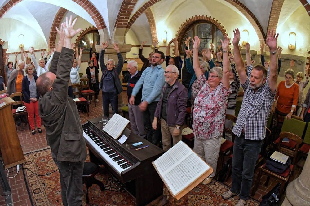 Bevor es mit der Probe zu Haydns „Schöpfung“ losgeht, wärmen sich die Sänger in der Petruskirche mit Gesangs- und Lockerungsübungen auf.