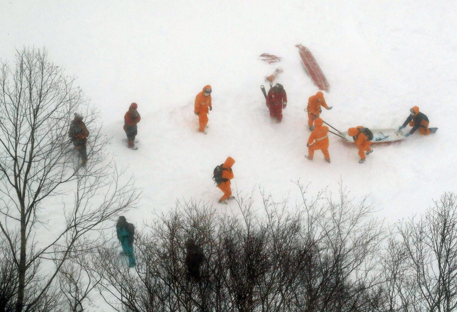 Feuerwehrleute suchen auf dem Ski-Freizeitgelände in Nasu nach den von einer Lawine erfassten verschütteten Schülern.