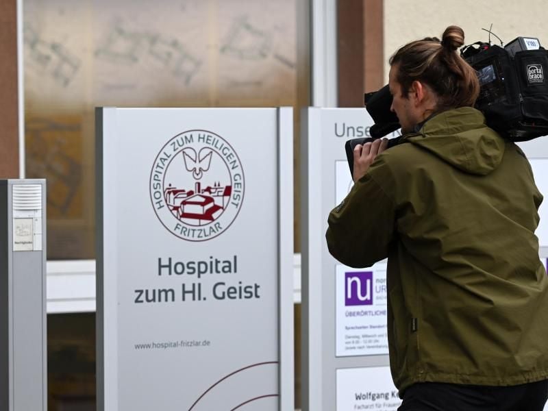 Ein Kameramann filmt das Schild am Haupteingang der Klinik "Hospital zum Heiligen Geist". Foto: Uwe Zucchi/dpa