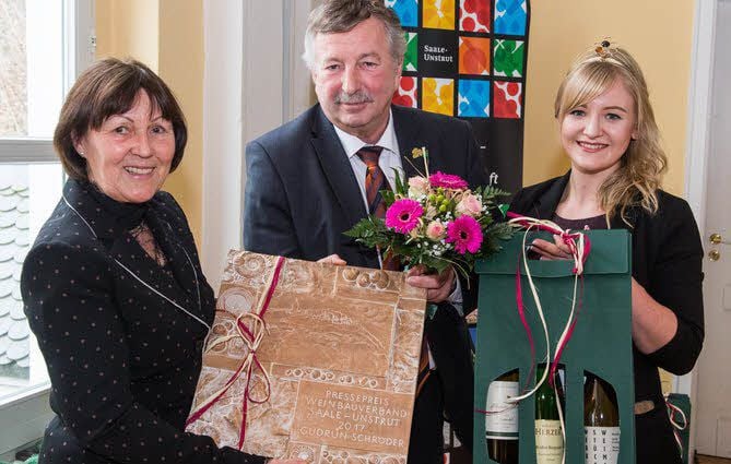 Gudrun Schröder (l.) wird von Weinkönigin Juliana Beer und Präsident Siegfried Boy mit dem Pressepreis geehrt.