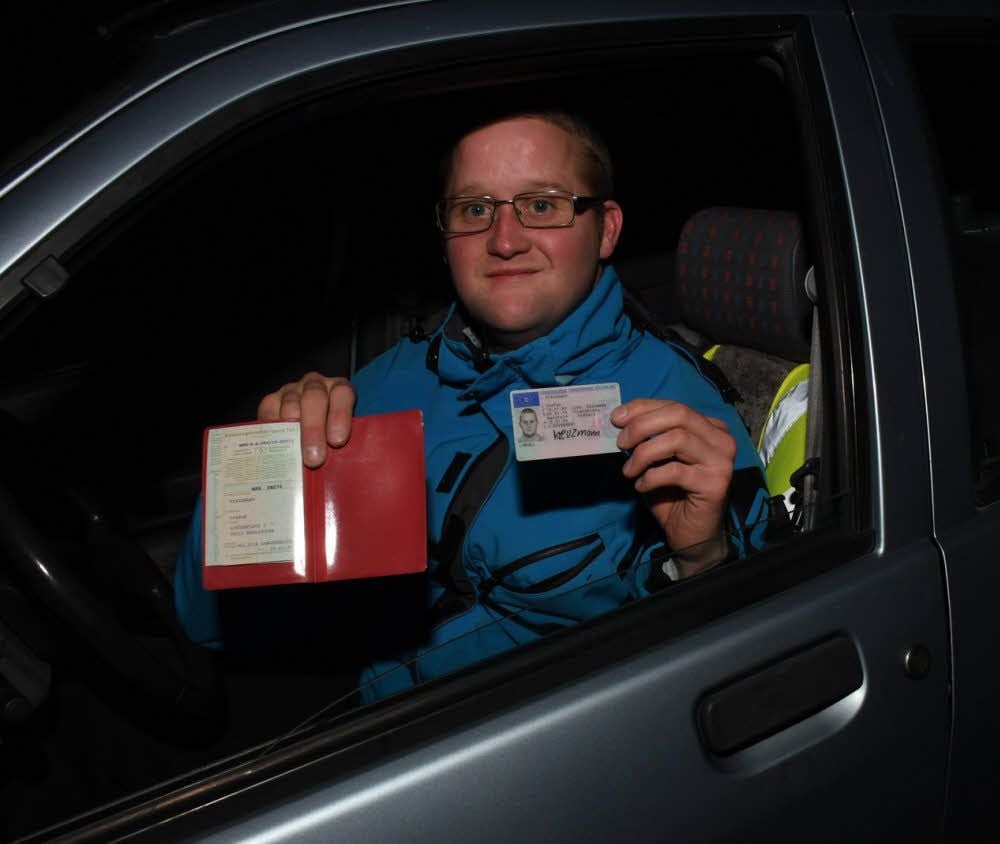Stefan Kreuzmann zeigt stolz den Führerschein und die Zulassung des Autos.