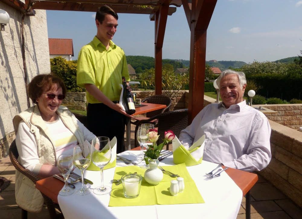 Landesmeister Marvin Fahnert serviert auf der Terrasse im Gasthaus Pretzsch in Zscheiplitz den Gästen einen Wein.