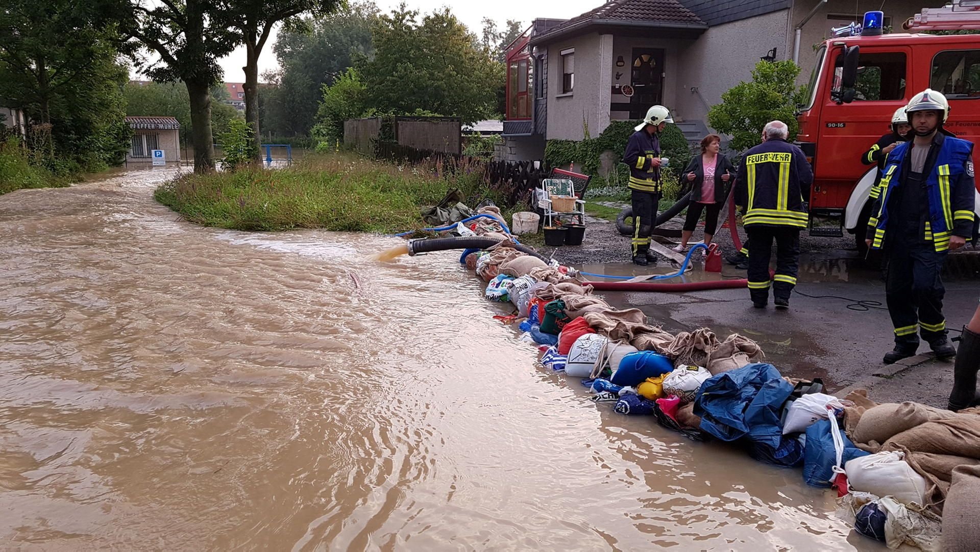 Feuerwehrleute aus Alsleben (Salzlandkreis) sichern mit Sandsäcken und Pumpen Häuser in Halberstadt vor Hochwasser.