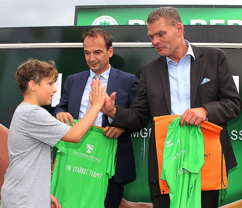 Der zehnjährige Leichtathlet Tom Hanke aus Bernburg klatscht sich unter den Augen von Landessportbund-Präsident Andreas Silbersack (MItte) mit Sportminister Holger Stahlknecht ab.