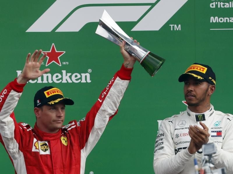 Kimi Räikkönen (l) feiert in Monza seinen zweiten Platz hinter Lewis Hamitlon. Die Personalie des Finnen bereitet Ferrari Entscheidungsprobleme. Foto: Antonio Calanni/AP