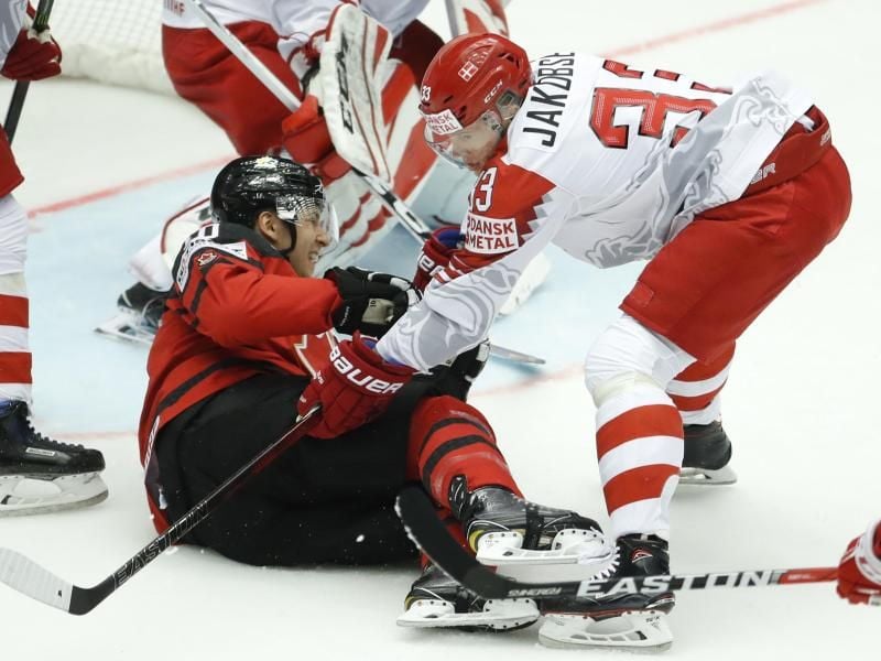 Beim Kampf um den Puck kommen der Däne Julian Jakobsen (r) und Brayden Schenn aus Kanada zu Fall. Foto: Petr David Josek/AP