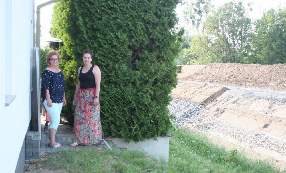 Hinter dem inzwischen weitgehend wieder hergerichteten Haus der Günthers in Gorsdorf wächst der Gegenstand ihrer Hoffnung, nie wieder Hochwasser auf dem Grundstück haben zu müssen - der neue Deich an der Schwarzen Elster. Corina (links) und Tochter Carolin sind seit Baubeginn spürbar erleichtert.