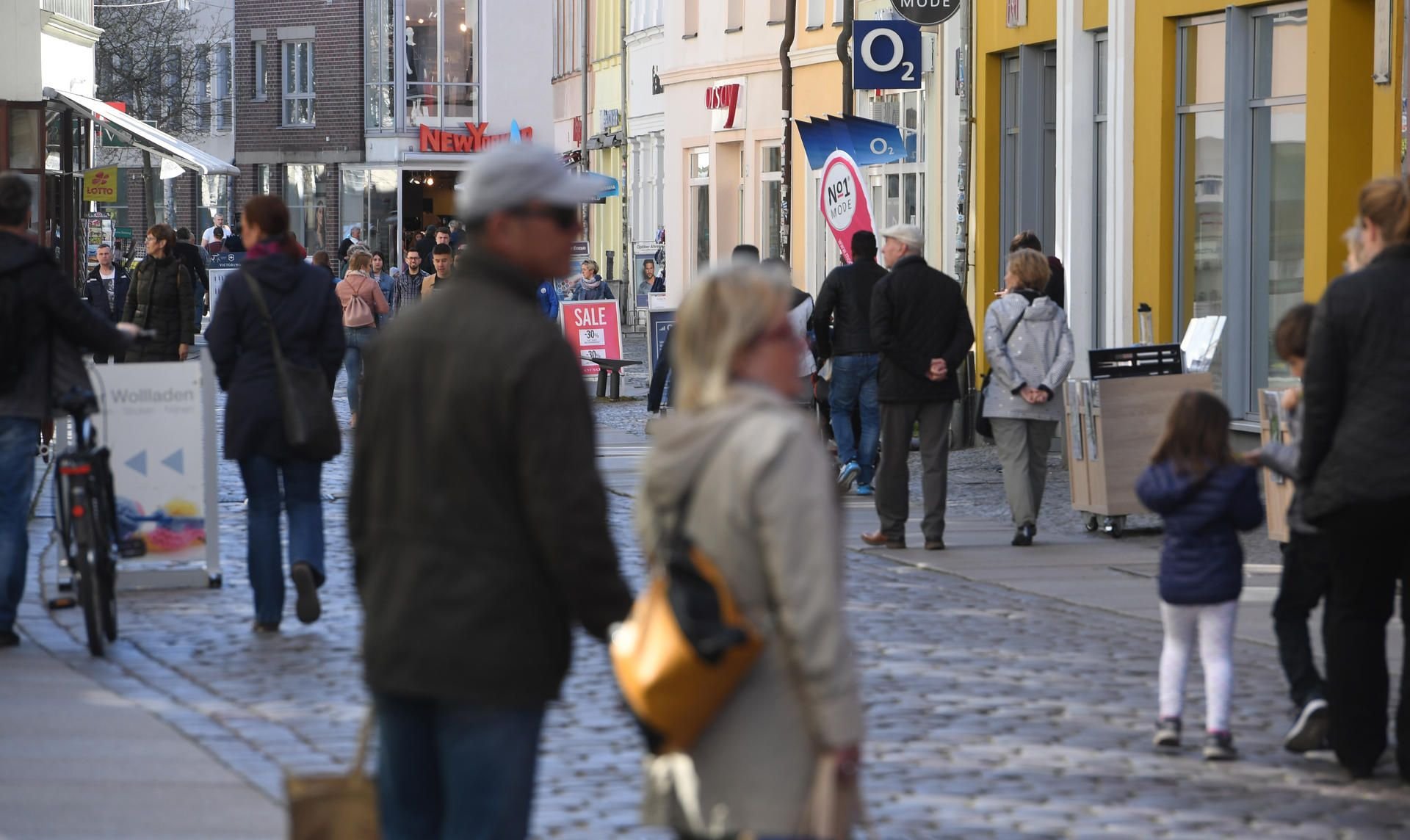 Menschen gehen durch die Einkaufstraße im Zentrum von Stralsund. Die verhältnismäßig niedrigen Corona-Infektionszahlen in den meisten ostdeutschen Bundesländern sind aus Expertensicht unter anderem auf demografische Faktoren zurückzuführen.
