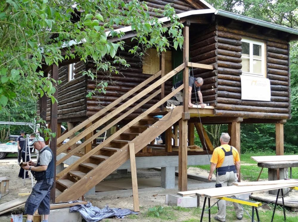 Hütte mit Hochwasserschutz: Den unteren Teil des als Blockhaus getarnten Fachwerkbaus bildet eine Betonkonstruktion, auf der ein Holzständerwerk ruht.