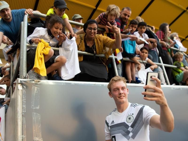 Julian Brandt macht beim Training des DFB-Teams ein Selfie mit den Fans. Foto: Federico Gambarini