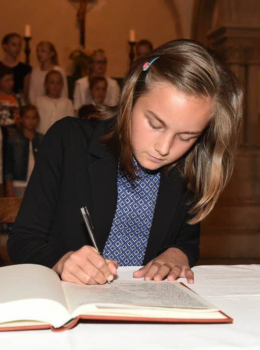 Henriette Wunderlich trägt sich in das Goldene Buch der Schule ein.