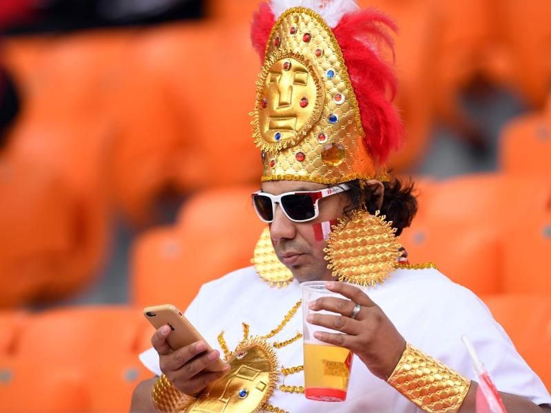 Ein kostümierter Fan des peruanischen Teams hat es sich vor dem Anpfiff des Spiels gegen Frankreich im Jekaterinburg-Stadion mit Getränk und Smartphone bequem gemacht. Foto:&nbsp;Marius Becker