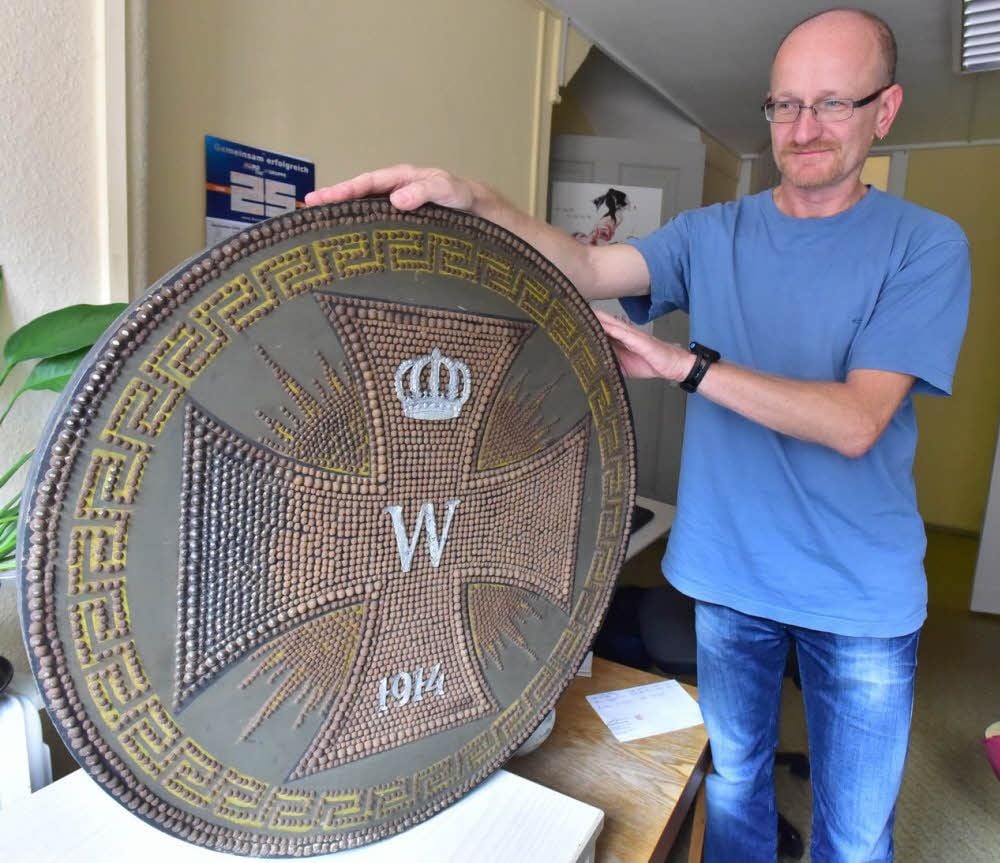 Mike Sachse mit einem der sogenannten Nagelbilder mit einem eisernen Kreuz, die als Leihgabe auf die Reise ins belgische Gent gegangen sind.