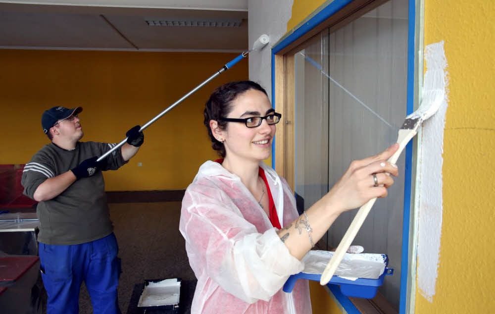 Sven Ulrich, Beschäftigter bei der Lebenshilfe Peißen, und Susann Franz, Lehrling im Toom-Baumarkt, streichen den Flur vom Verwaltungsgebäude.
