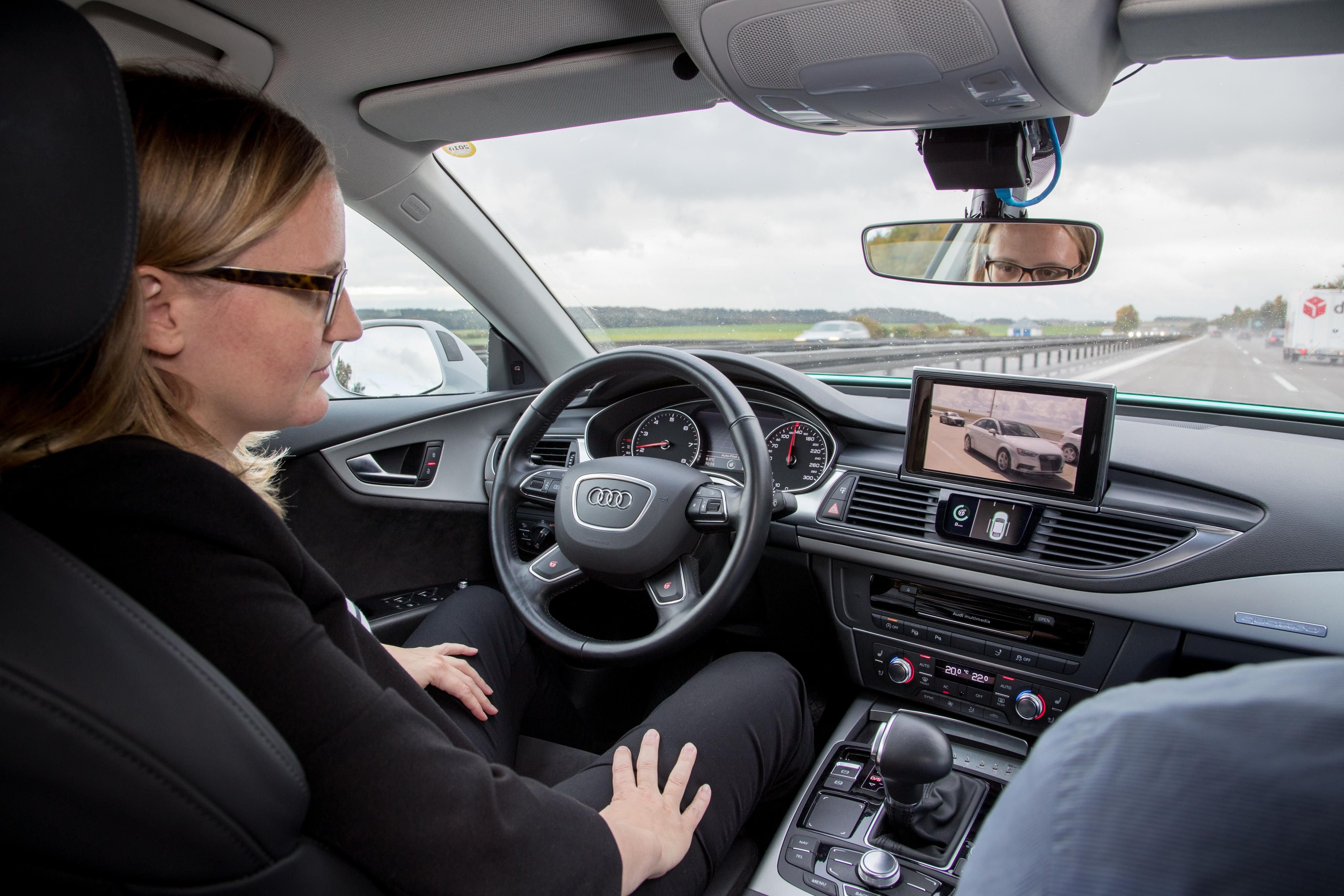 Eine Ingenieurin des Autoherstellers Audi sitzt in einem selbstfahrenden Wagen. In wenigen Jahren soll dieses Bild Alltag im Straßenverkehr sein.