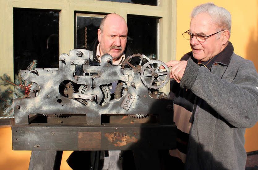 Der Bad Schmiedeberger Uhrmachermeister Jörg Gebser (links) und Karl-Heinz Keller besehen sich das Uhrwerk, das wieder hergestellt werden soll.