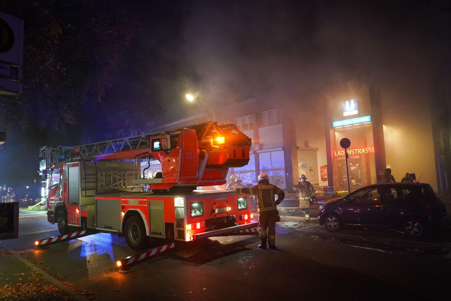 Einsatzkräfte der Feuerwehr beim Löschen eines Brandes in der Ladenzeile des U-Bahnhofs Onkel Toms Hütte.