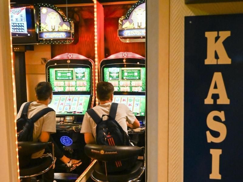 Ein Spieler sitzt in einer Spielhalle vor einem Automaten. Foto: Uwe Zucchi/dpa