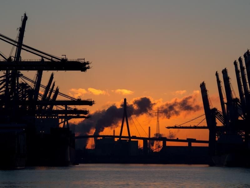 Die Köhlbrandbrücke vor Sonnenaufgang im Hafen in Hamburg. Im Vordergrund ein Containerschiff am Terminal Burchardkai. Foto: Daniel Reinhard