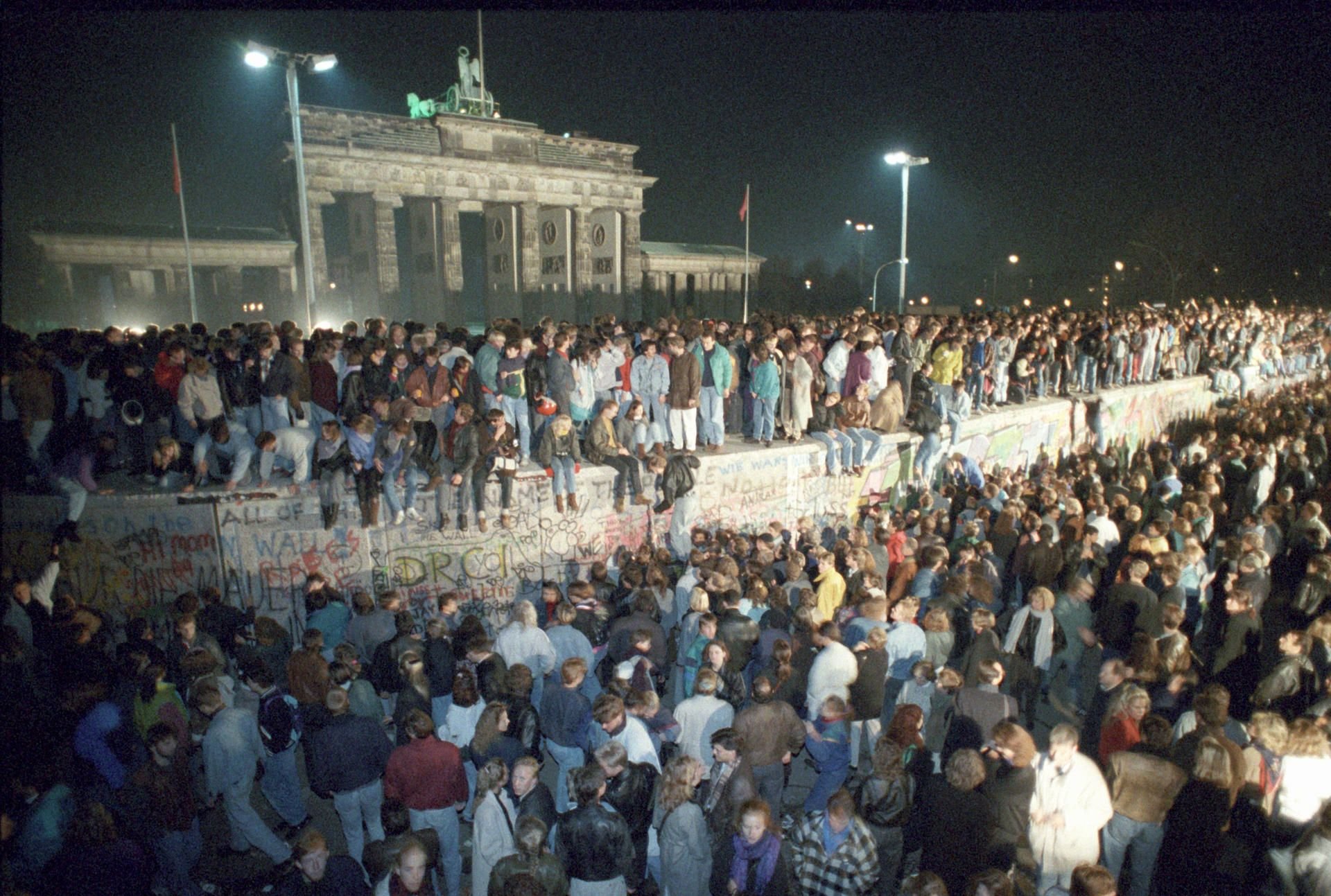 Menschen auf der Berliner Mauer vor dem Brandenburger Tor in der Nacht vom 9. auf den 10.11.1989.