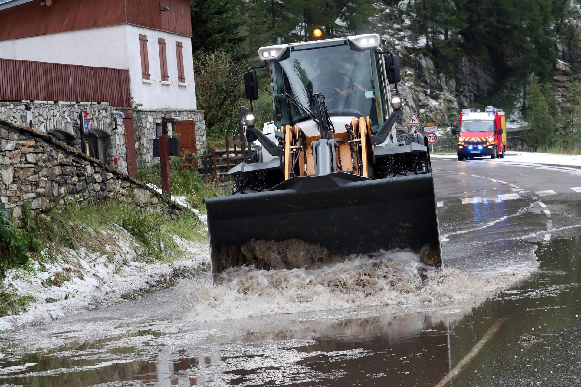 Mit einem Bagger werden die Wassermassen beseitigt.