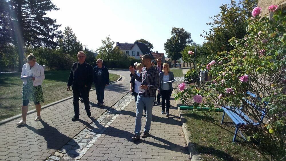 Ortsbürgermeister Marcus Fleischer (vorn) führt die Bewertungskommission und Falkensteins Bürgermeister Klaus Wycisk (l.) durch Neuplatendorf.