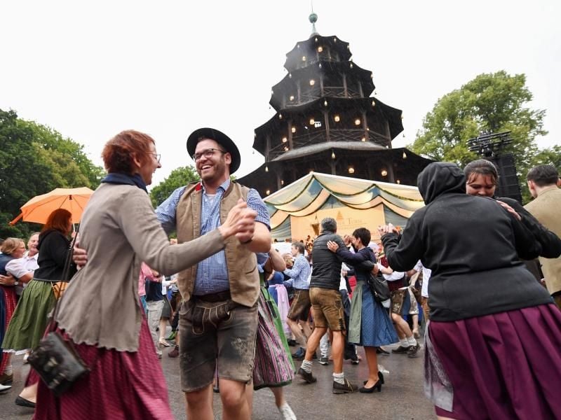 Fröhliche Gesichter beim Kocherlball am Chinesischen Turm in Münchens Englischem Garten. Foto: Tobias Hase