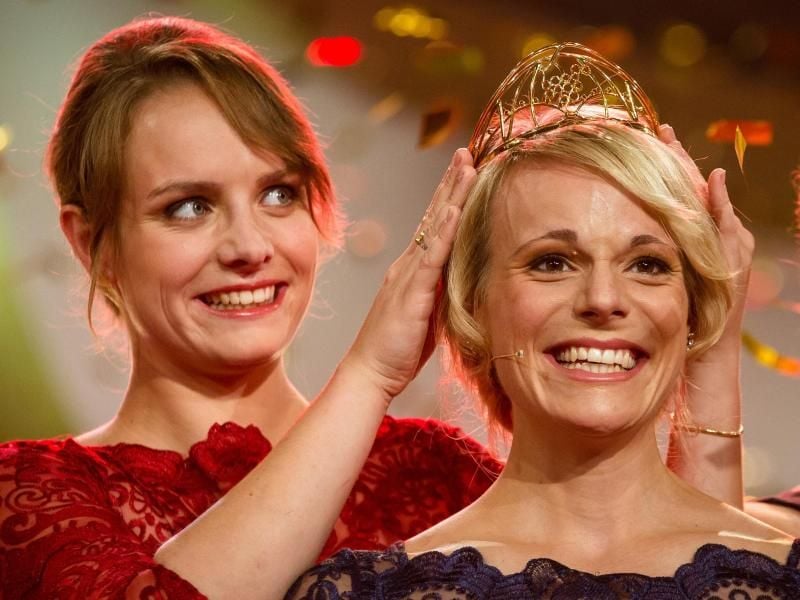 Die bisherige Weinkönigin Lena Endesfelder (l) übergibt der Siegerin Katharina Staab die Krone. Foto: Christoph Schmidt