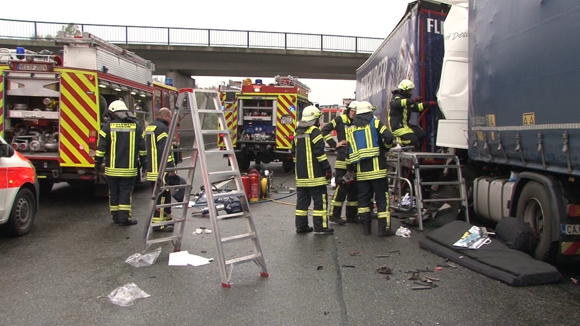 Feuerwehrleute bergen auf der Autobahn 1 bei Bakum den Fahrer eines Lkw. Bei mehreren Unfällen in dem Streckenabschnitt starben zwei Personen.