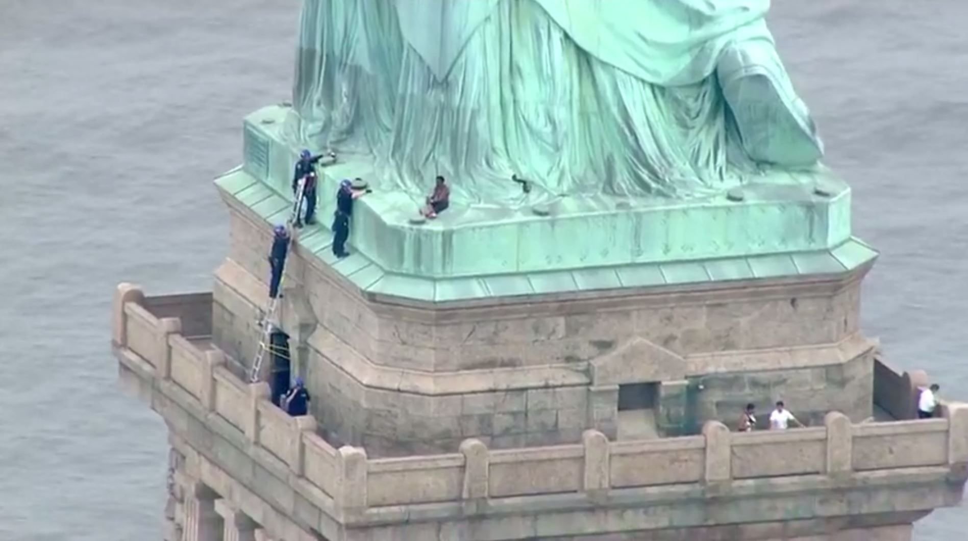 Die Polizei holt eine Aktivistin vom Sockel der Freiheitsstatue herunter.