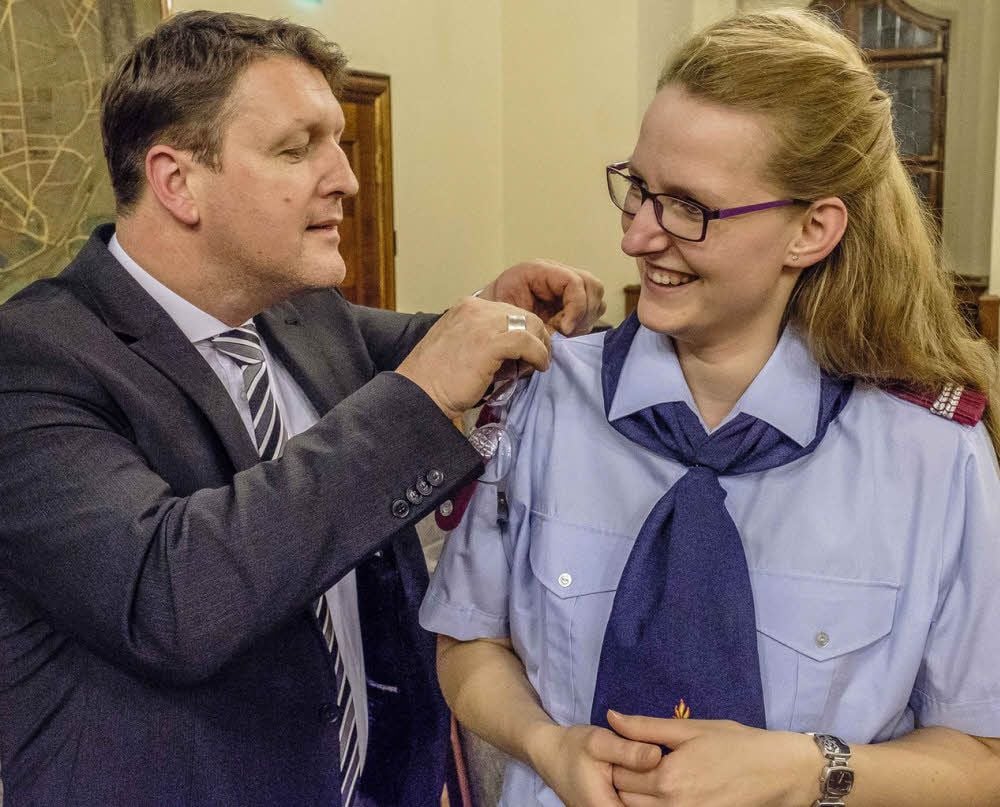 Da hilft schon mal die oberbürgermeisterliche Brille beim Anbringen des neuen Dienstgrad-Abzeichens. Oberfeuerwehrfrau Lydia Hatscher aus Pratau genießt die Ehre, dass Torsten Zugehör selbst Hand anlegt.