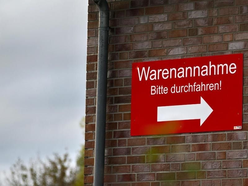 Ein Schild an der Wand eines Gebäudes auf dem Firmengelände der Fleisch-Krone-Feinkost GmbH weist den Weg zur Warenannahme. Foto: Mohssen Asssanimoghaddam/dpa