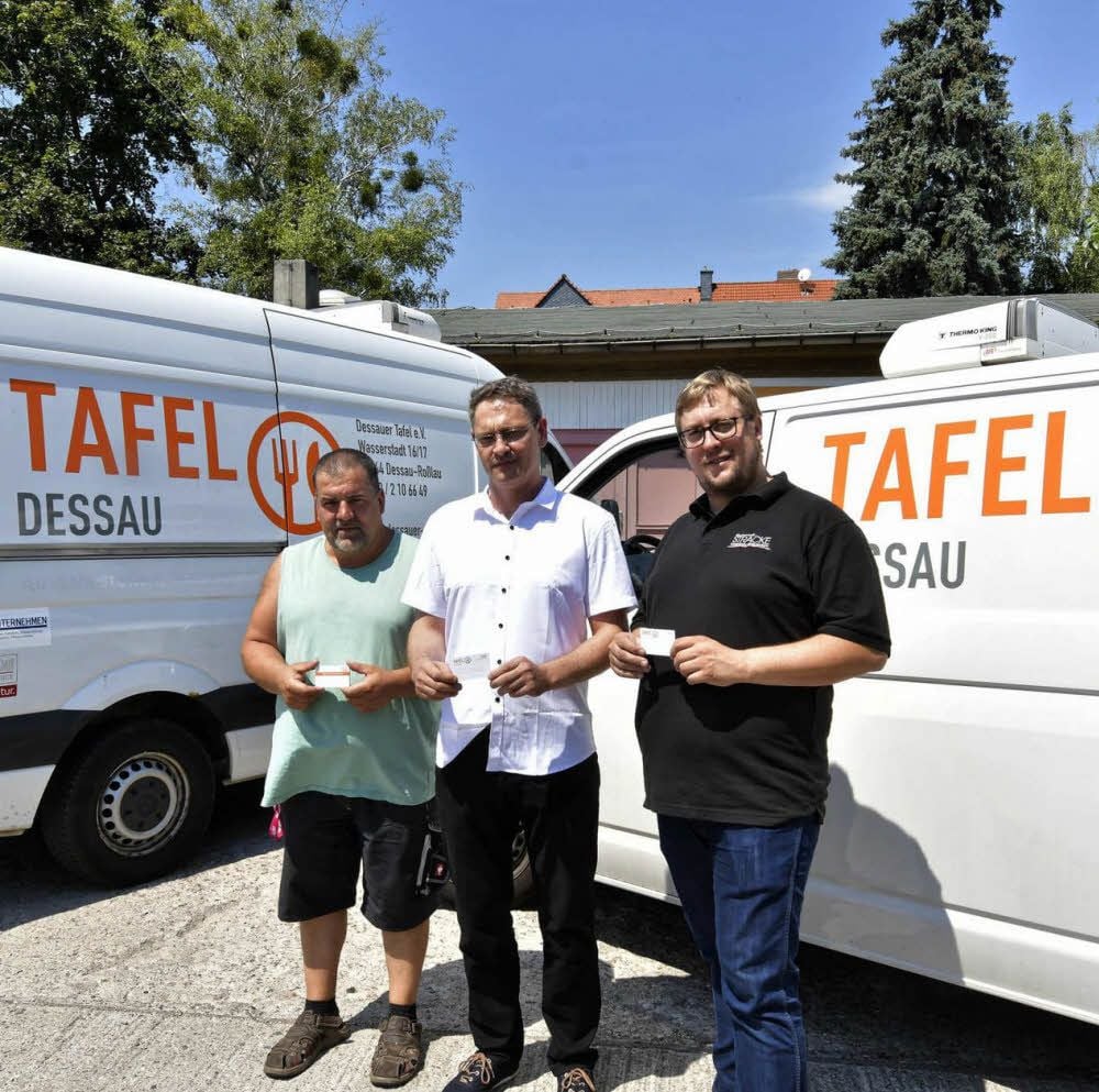 Andreas Lohpens, Matthias Spröte und Steffen Strömer vor den neuen Logos an den „Tafel“-Autos.