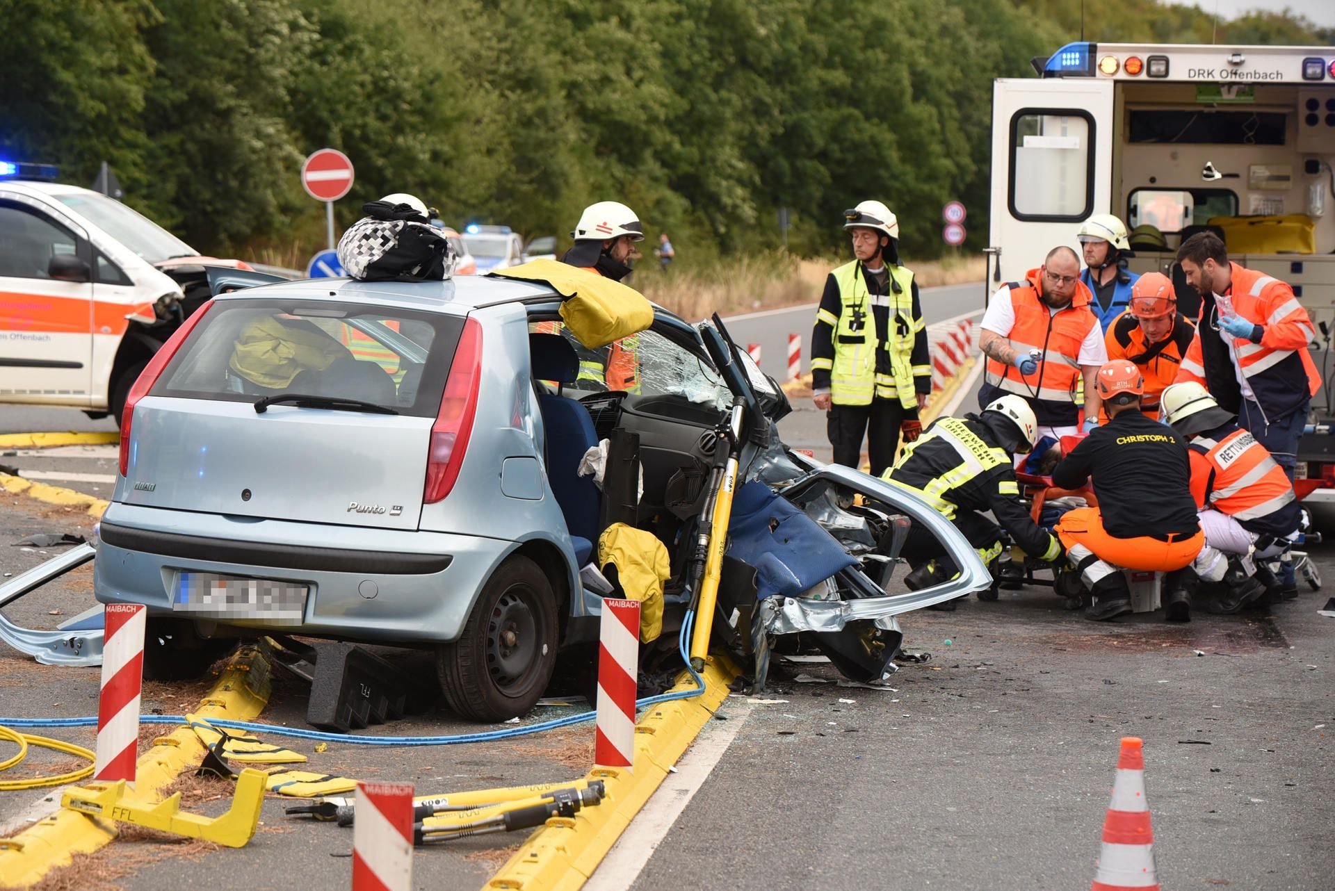 Rettungssanitäter betreuen einen Schwerverletzten. Ein Notarztwagen im Einsatz ist dort auf der Landstraße zwischen Dreieich und Götzenhain mit einem anderen Auto zusammengestoßen.